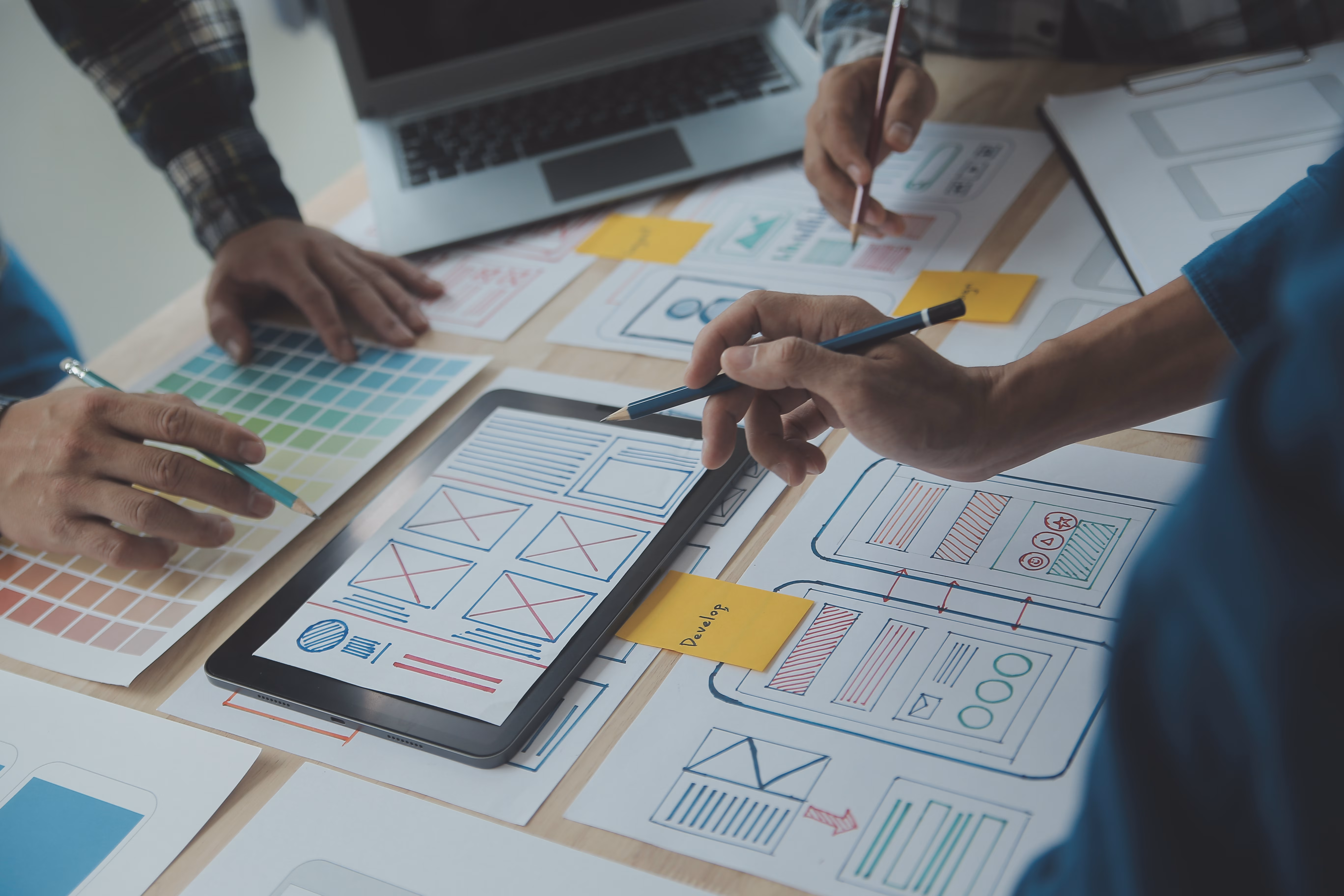 UX Design Research Group, around table looking at hand-drawn wireframes